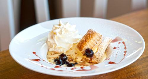 a white plate with a piece of cake and whipped cream at Albergo Ristorante Siro in Torgiano