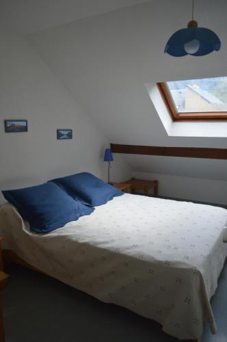 une chambre avec un lit avec des oreillers bleus et une fenêtre dans l'établissement BEL AURE 3, à Saint-Lary-Soulan