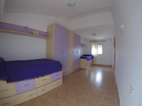 a bedroom with a bed with purple sheets and cabinets at Chalet Bri in Peniscola