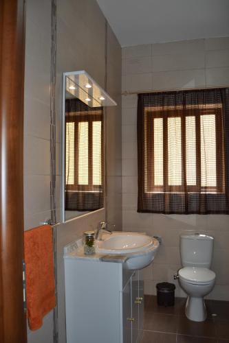 a bathroom with a sink and a toilet and a mirror at Mellieha Town Centre Bright & Spacious 3 Bedroom Apartment in Mellieħa