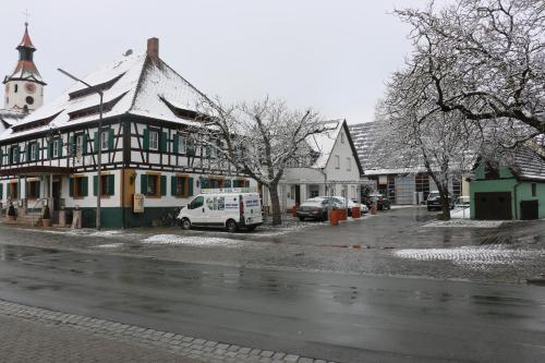 a building with a van parked on the side of a street at Landhotel Rangau Gasthof & Brennerei in Markt Erlbach