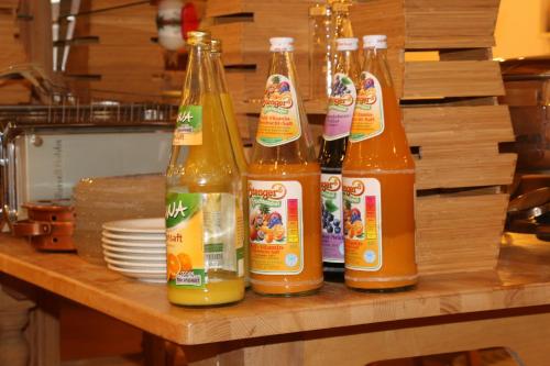 Landhotel Rangau Gasthof & Brennerei في Markt Erlbach: مجموعة من اربع زجاجات على طاولة