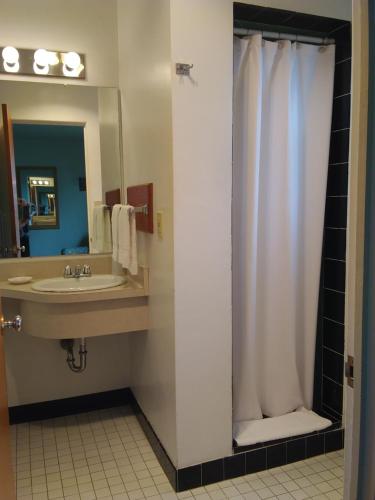 a bathroom with a sink and a shower curtain at Bay Bridge Motel in North Bend