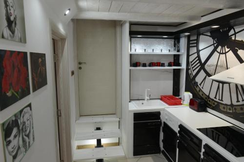 a small kitchen with a sink and a clock at Apartman Rustik in Belgrade