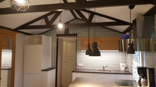 a kitchen with two pendant lights hanging from the ceiling at Cozy home in between Malmö & Lund in Åkarp