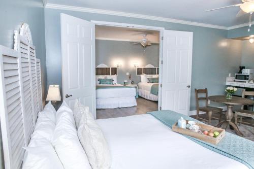 a bedroom with a white bed and a room with a table at The Rigdon House in Cambria