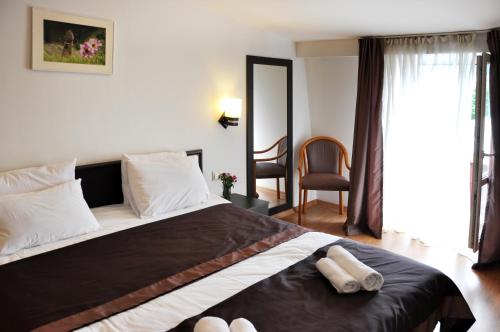 a bedroom with a large bed with two towels on it at Hotel Corner in Tbilisi City