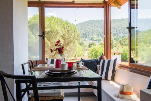 a dining room with a table and a large window at Maistros Holiday Home in Vourvourou