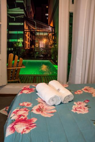 a table with two towels and a swimming pool at Casa Tuxi in Rio de Janeiro