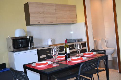 a kitchen with a table with wine glasses on it at Le Malte House St. Julians in St Julian's