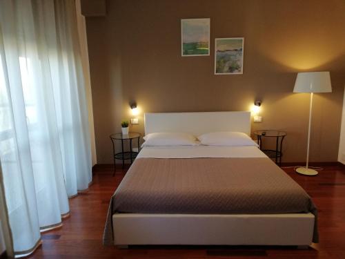 a bedroom with a large bed and two windows at B&B Giulio Cesare in Vasto