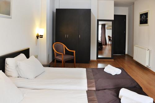 a hotel room with a bed and a chair at Hotel Corner in Tbilisi City