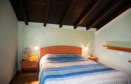 - une chambre avec un lit doté d'une tête de lit en bois dans l'établissement B&B Aria Di Lago, à Paratico