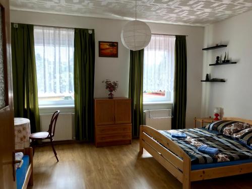 ブロウモフにあるUbytování Janinaのベッドルーム1室(ベッド1台、椅子、窓付)