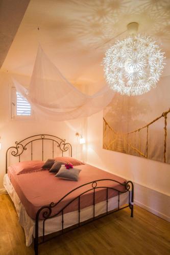 a bedroom with a bed with a chandelier at Carre Royal in Deshaies
