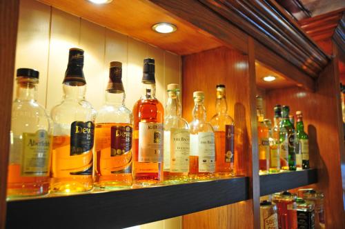 a shelf filled with lots of bottles of alcohol at Schiehallion Hotel in Aberfeldy