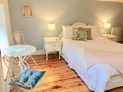 1 dormitorio con cama blanca y mesa en Riverside House en Newport