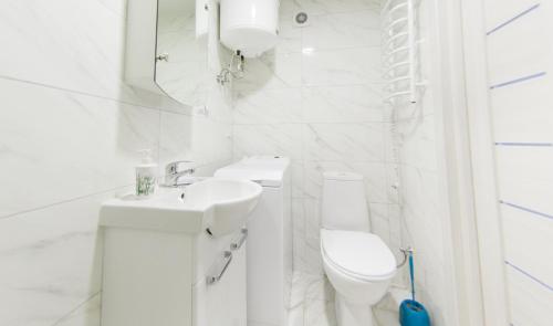 a white bathroom with a toilet and a sink at EasyStay inn in Kyiv