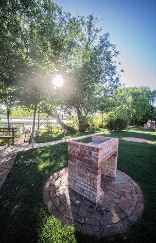 a brick bench in a park with the sun shining at Enpi Lake Resort in Iaşi