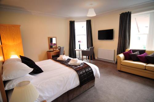 a hotel room with a bed and a couch at Schiehallion Hotel in Aberfeldy