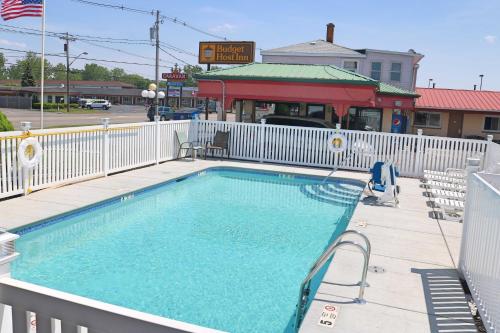 une grande piscine avec une clôture blanche dans l'établissement Woodland Inn, à Niagara Falls