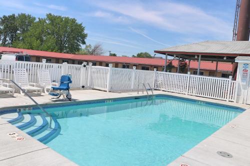 a swimming pool at a hotel with a white fence at Woodland Inn in Niagara Falls