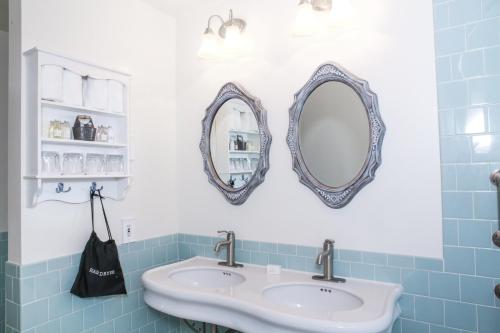 a bathroom with two mirrors and a sink at The Rigdon House in Cambria