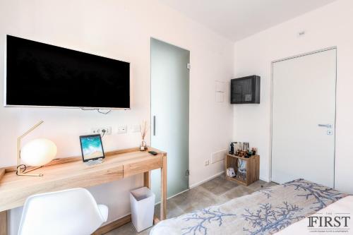 a bedroom with a desk and a tv on the wall at Il Sogno di Manarola by The First in Manarola
