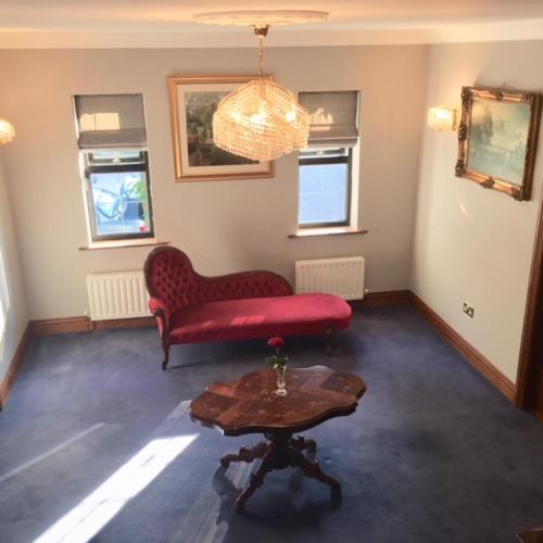 a living room with a red couch and a table at Ivy House in Galway