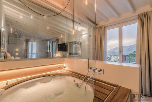 a bath tub in a bathroom with a large window at Il Sogno di Manarola by The First in Manarola
