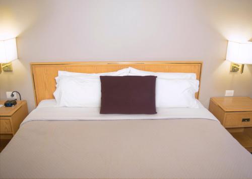 a bedroom with a large bed with white pillows at iStay Hotel Monterrey Histórico in Monterrey