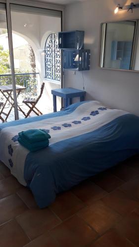 イエールにあるvilla le grilladouの青い毛布付きのベッド1台