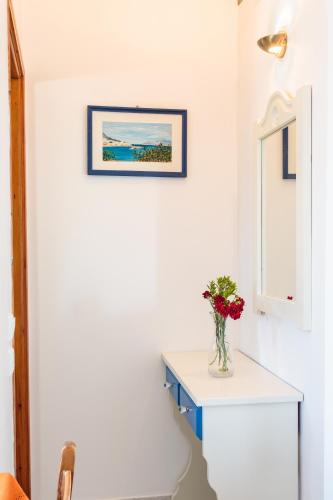 a white room with a vase of flowers on a table at Ragoussis House in Logaras