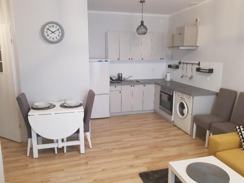 a small kitchen and living room with a table and chairs at Apartament Grottgera in Kłodzko