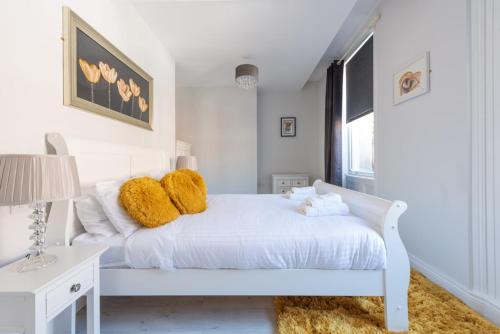 ロンドンデリーにあるDiamond House Apartmentsの白いベッドルーム(黄色い枕の白いベッド付)