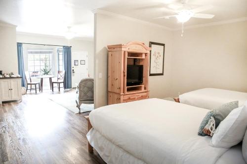 a bedroom with two beds and a flat screen tv at The Rigdon House in Cambria