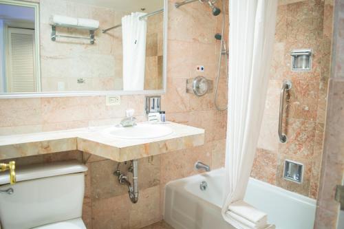 a bathroom with a sink and a toilet and a shower at iStay Hotel Monterrey Histórico in Monterrey