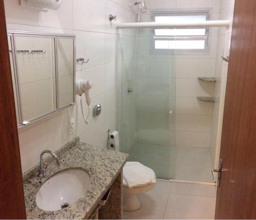 a bathroom with a sink and a glass shower at Pousada e Camping Lagoa da Conceição in Florianópolis