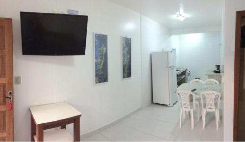 a living room with a table and a refrigerator at Pousada e Camping Lagoa da Conceição in Florianópolis