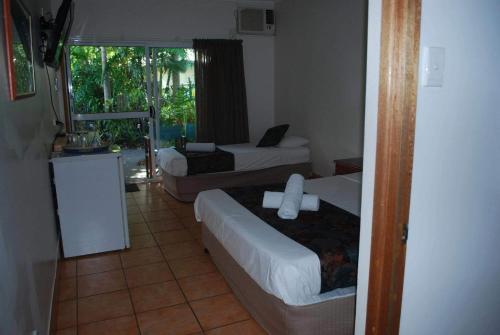 Habitación de hotel con 2 camas y ventana en Rainforest Motel, en Mission Beach