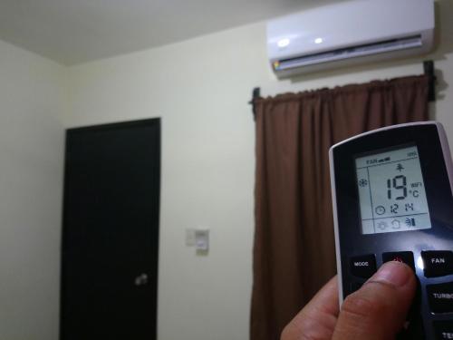 a hand holding a thermometer in front of a room at Hotel Popeye in Ciudad Valles