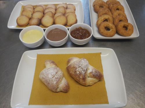a table with two trays of food with donuts and dips at Agriturismo Tenuta La Siesta in Gallipoli