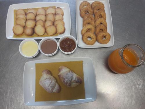a table topped with three plates of food with doughnuts at Agriturismo Tenuta La Siesta in Gallipoli