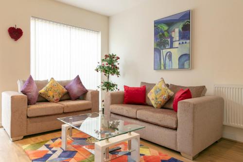 a living room with two couches and a glass table at Modern & Exquisite Trumpington Townhouse with Parking & 5 mins to Papworth hospital in Cambridge