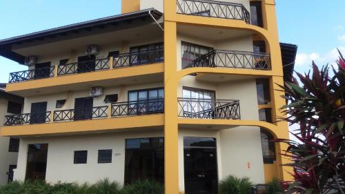 a yellow and white building with balconies at Hotel Da Vila in Joinville