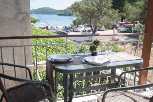 a table on a balcony with a view of the water at Ta Kavourakia in Mikros Gialos