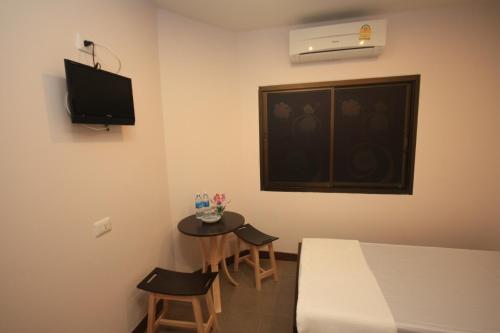 a room with a table and a bed and a window at Ming Shou Boutique House in Phuket Town
