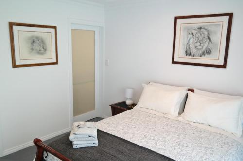 - une chambre avec un lit et 2 photos sur le mur dans l'établissement Just triggin, à Perth