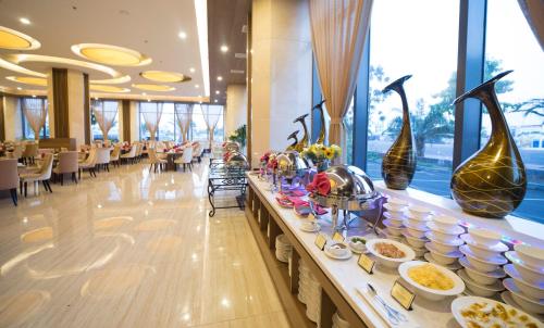 a buffet line in a restaurant with tables and chairs at Muong Thanh Luxury Ca Mau Hotel in Cà Mau