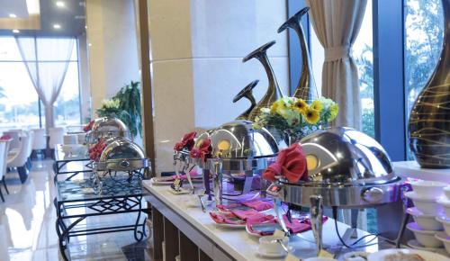 a buffet line with helmets and plates on a table at Muong Thanh Luxury Ca Mau Hotel in Cà Mau